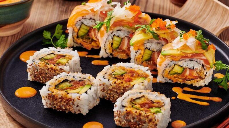 Sushi Roll Salmon segar dengan potongan alpukat dan mentimun, disajikan dengan biji wijen panggang