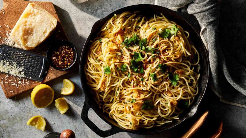 Seporsi spaghetti aglio olio dengan bawang putih dan cabai, disajikan hangat dengan taburan peterseli segar yang memberikan aroma harum khas Italia