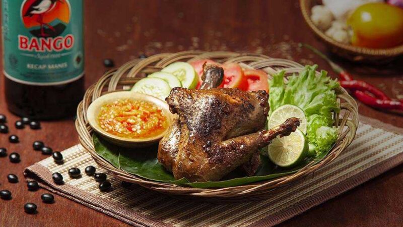 Ayam bakar pedas yang disajikan dengan warna kecokelatan menggoda, beraroma bumbu rempah dan cabai.