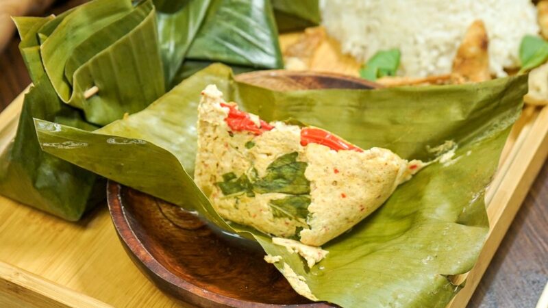 Pepes tahu tradisional yang dibungkus daun pisang, dengan aroma rempah khas dan tekstur lembut