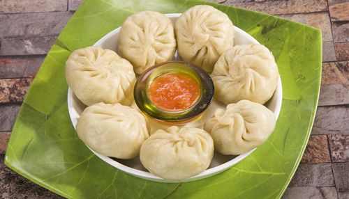 Delicious paneer-stuffed Momos garnished with fresh herbs 